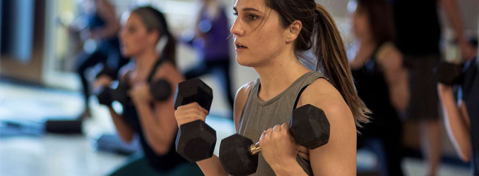 Woman lifting weights in an FFC Hiit class.