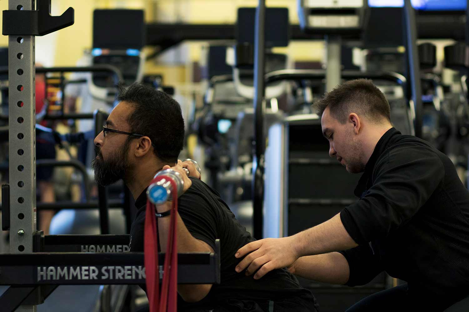 Personal trainer working with a client with weights.