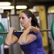 Woman lifting barbells during a personal training session.