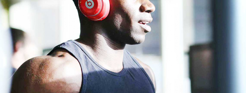 Man running on treadmill with headphones on listening to music