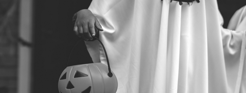 A person dressed up as a ghost trick or treating