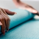 Woman rolling up a yoga mat.
