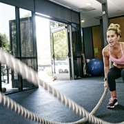 Woman working out with battle ropes.