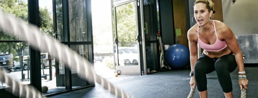 Woman working out with battle ropes.