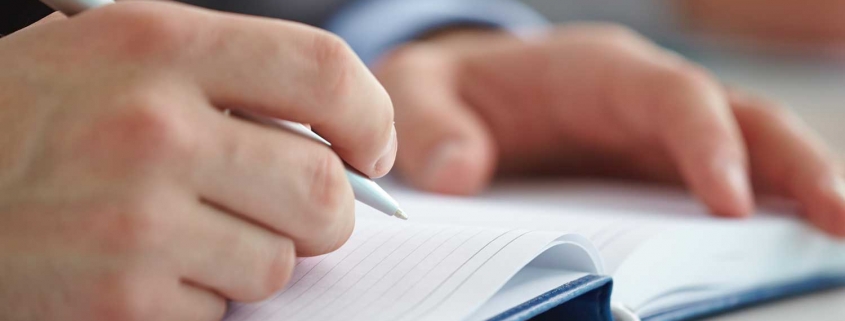 A man writing notes at a fitness workshop
