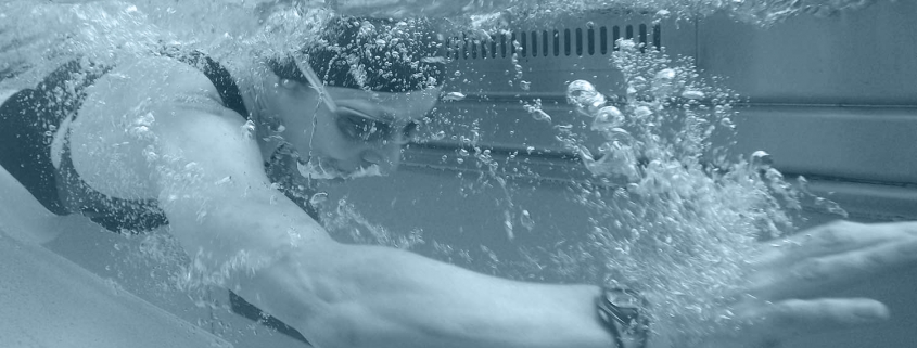 Side view of a woman swimming in a pool.