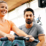 Image of a woman using a rowing machine with a personal trainer.