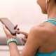 Female runner holding phone and listening to music with headphones on.