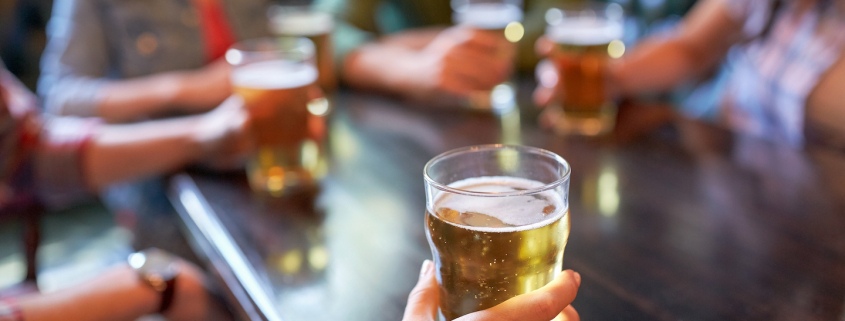 friends drinking beer and at bar or pub