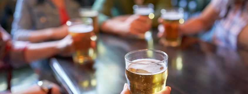 Image of friends drinking beer together in a bar.