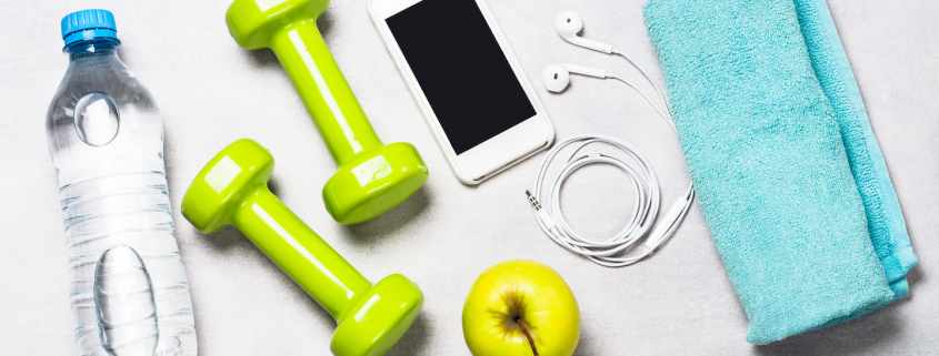 Dumbbells, measuring tape, water and smartphone top view. Fitness concept and healthy lifestyle.