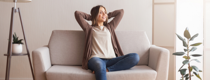 Millennial girl relaxing at home on couch, enjoying weekends, empty space