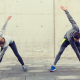 Man and woman outside in running gear stretching