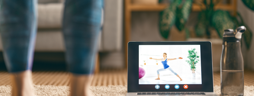 woman with ipad watching yoga class at home