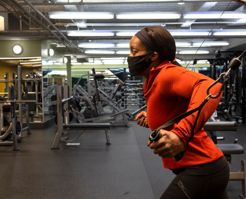 Woman using weight machine at gym