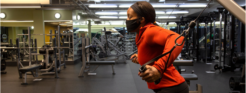 Woman using weight machine at gym