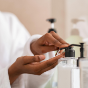 Woman using body lotion dispenser