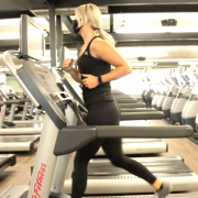 Woman running on treadmill wearing a mask