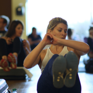 Woman performing ab exercise in a Fitcore group fitness class in Chicago