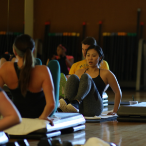 Men and women performing ab exercises in a Triple Threat group fitness class in Chicago