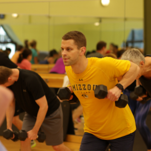 Man lifting weights in a Chisel group fitness class in Chicago