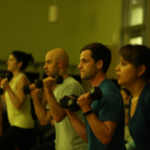 Men lifting weights in a Critical Mass group fitness class in Chicago