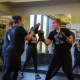 Two women participating in a small group boxing class at a gym