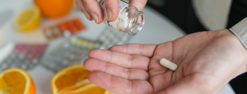 Person with a dietary supplement pill in their hand.