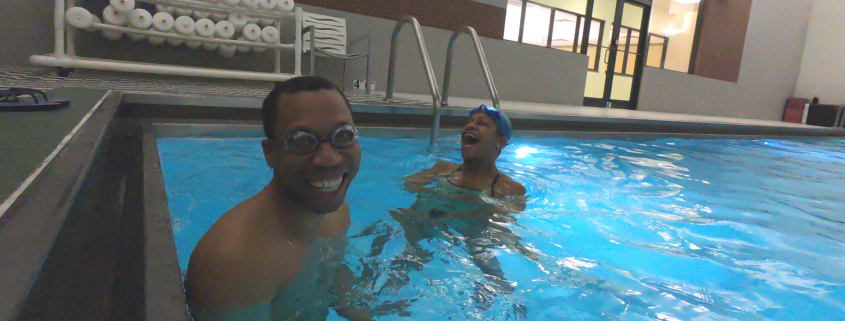 Juan smiling in pool with trainer Joy