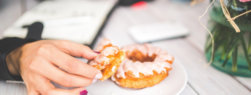 Photo of a hand reaching for a donut