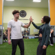 A man and woman high fiving in a gym