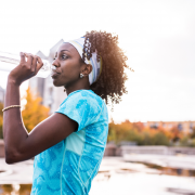 Woman drinking water out of a water bottle outside