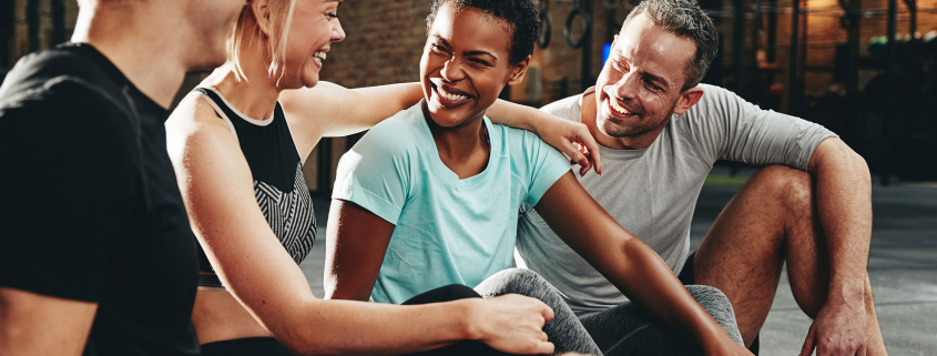 Friends laughing with each other in a gym.