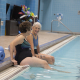 Two older women sitting on the edge of a pool