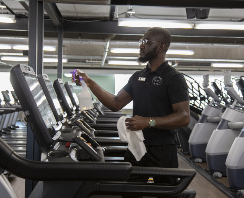 A man cleaning a treadmill