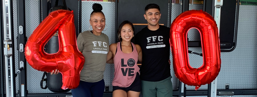 3 people in a studio holding a 4 and a 0 balloon