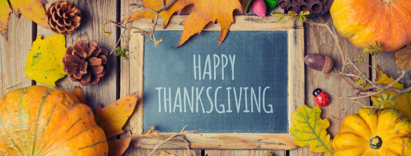 Thanksgiving background with chalkboard. Autumn pumpkin and fall leaves on wooden table. View from above