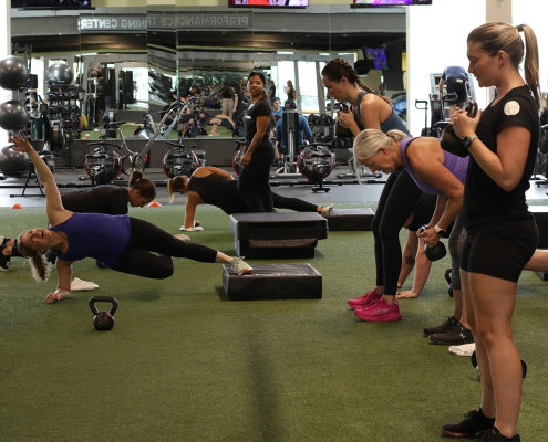 Group fitness class with kettlebells on turf