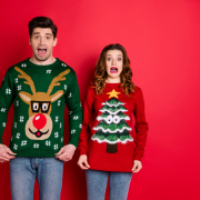 Two people wearing ugly Christmas sweaters