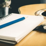 Guitar with a pen and notepad next on it