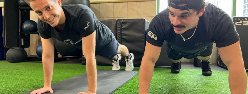 Personal Trainer teaching proper plank form at Gold Coast Gym.