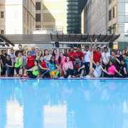 Group fitness dance class on outdoor pool deck.