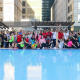 Group fitness dance class on outdoor pool deck.