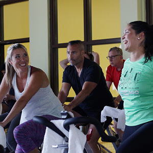 Photo of FFC members smiling while working out on the cycle machines