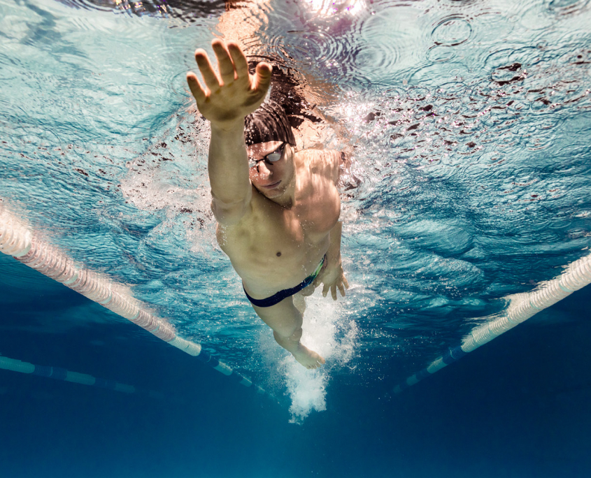 Swimmer in the pool close up under water