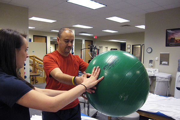 Member getting assistance with medicine ball at Rush Medical center inside one of our 10 locations.