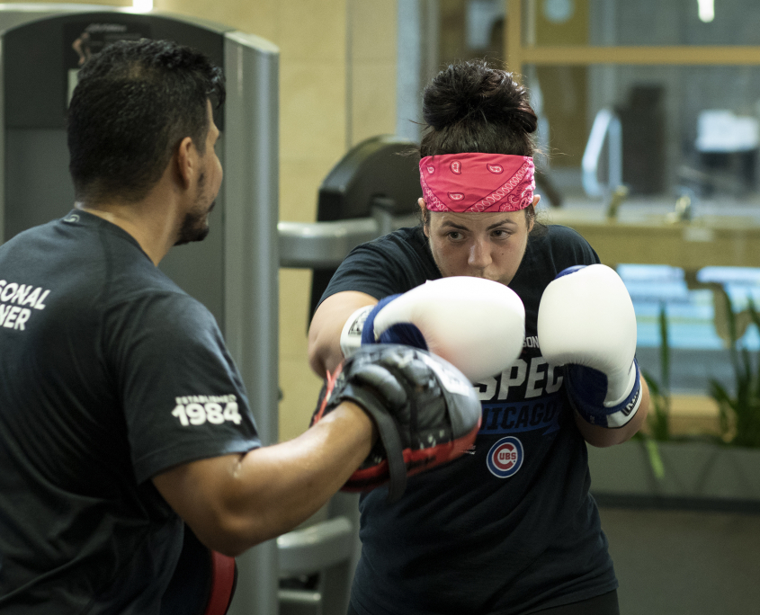 Personal trainer assisting boxing client at FFC West Loop