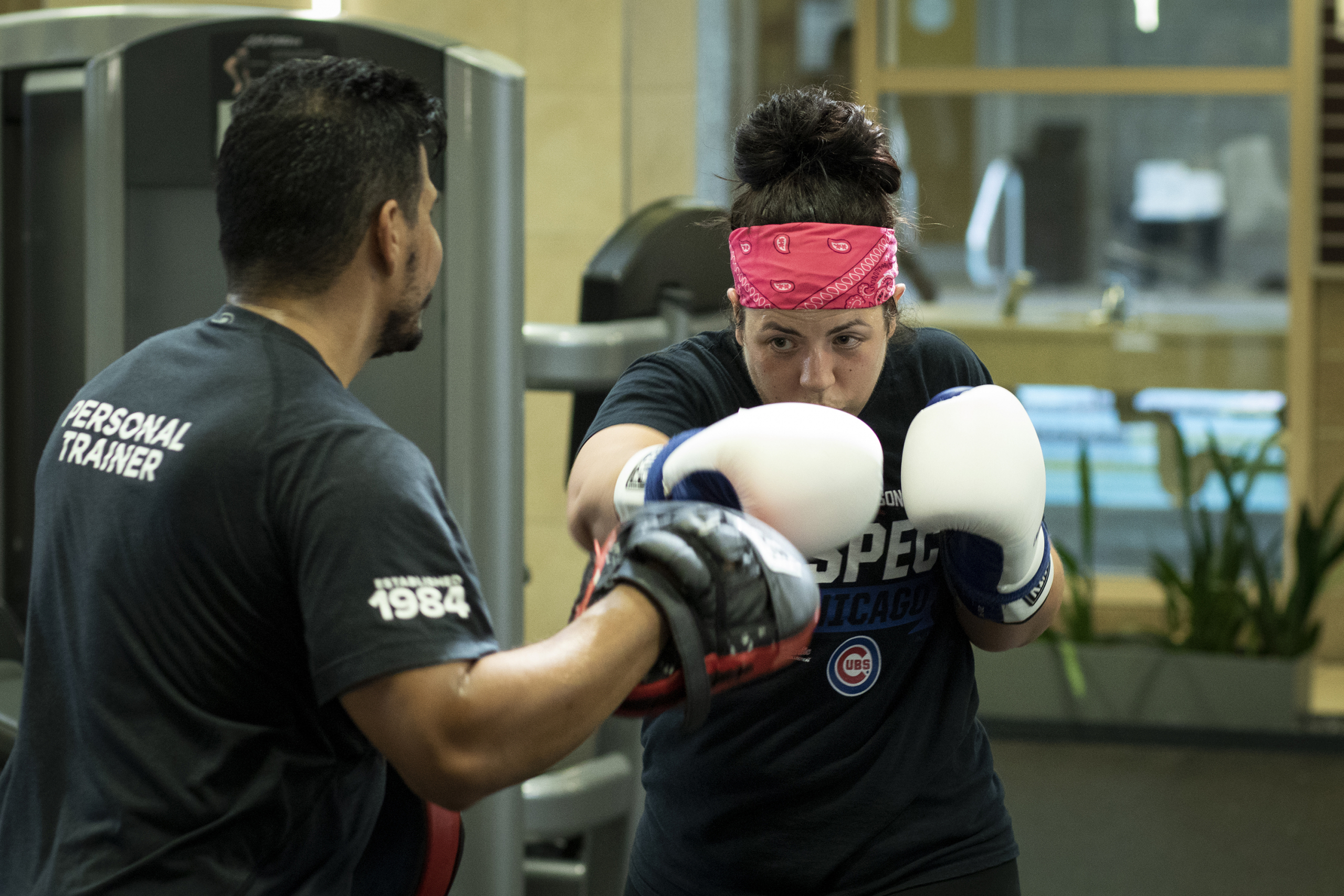 Personal trainer assisting boxing client at FFC West Loop